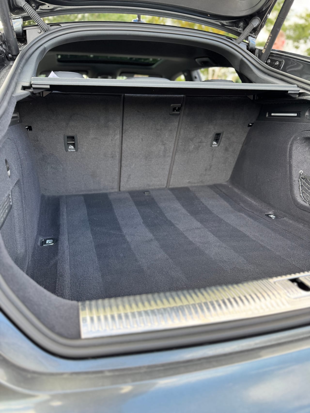 Sauberer Kofferraum eines Audi mit gründlich gereinigtem Teppich und Ladekantenschutz.