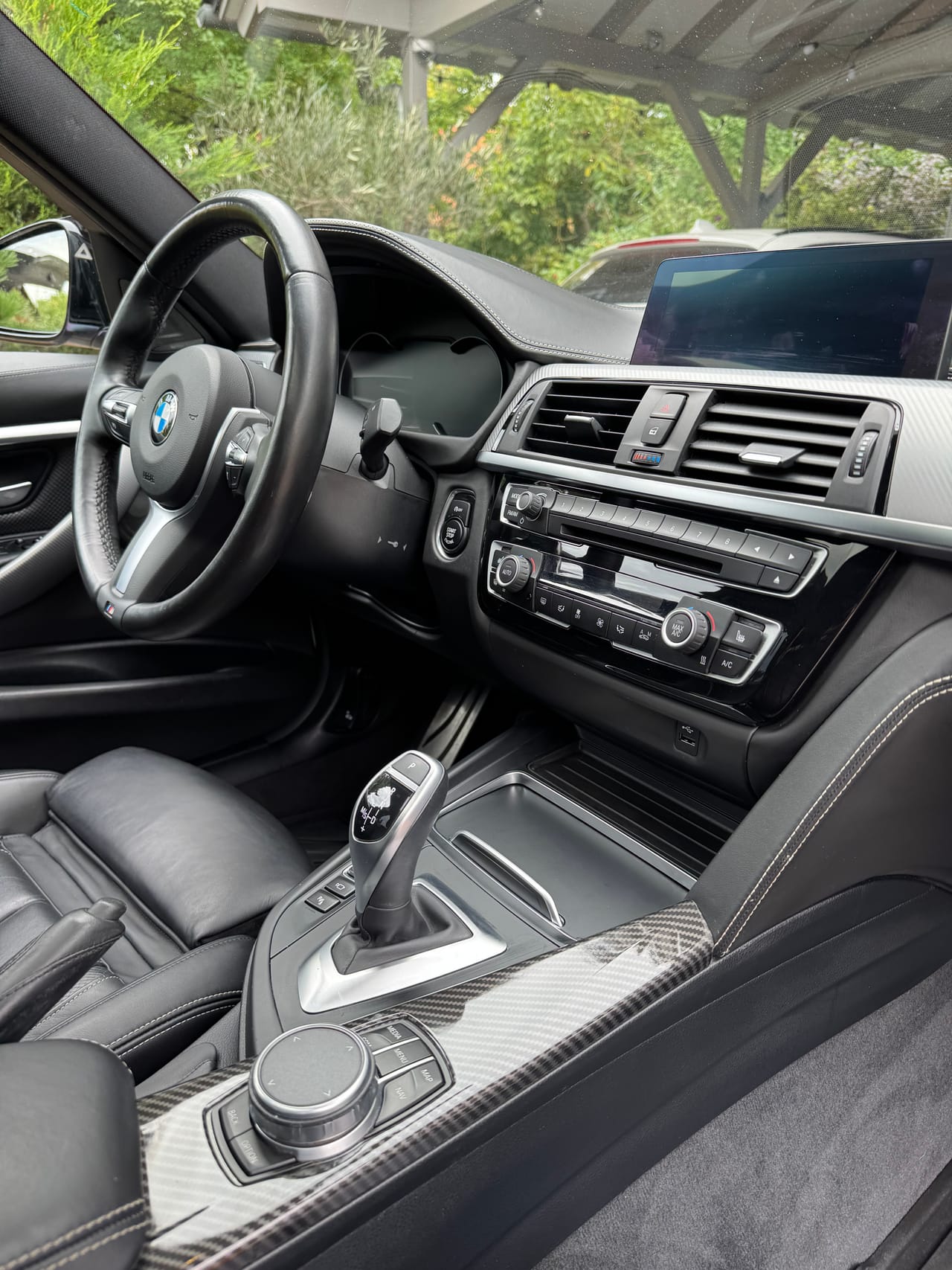 Cockpit und Mittelkonsole eines BMW M mit Carbon-Dekor, frisch gereinigter Innenraum.