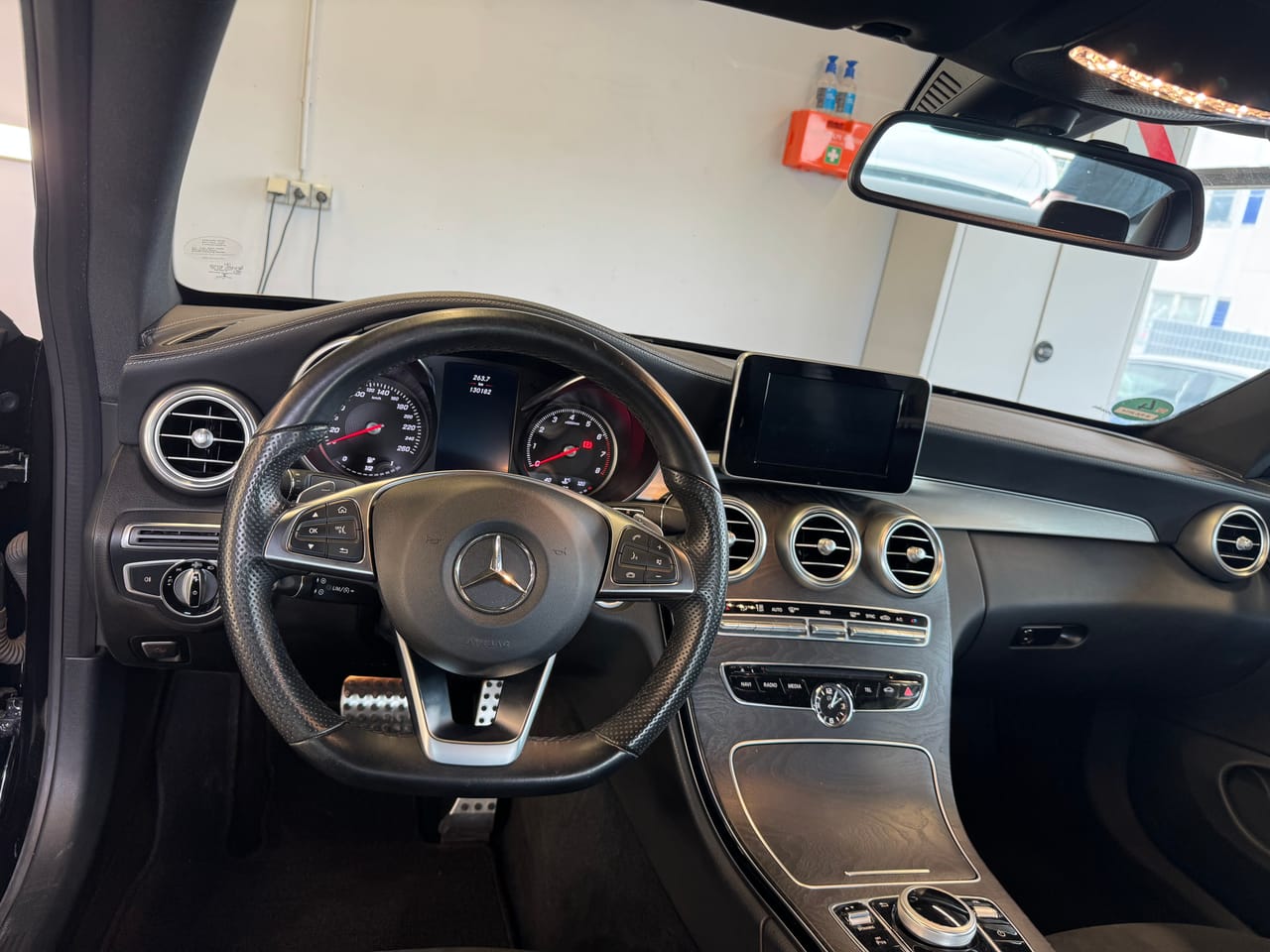 Cockpit eines Mercedes C-Coupé mit AMG-Lenkrad, Tacho und Mittelkonsole nach gründlicher Innenaufbereitung.